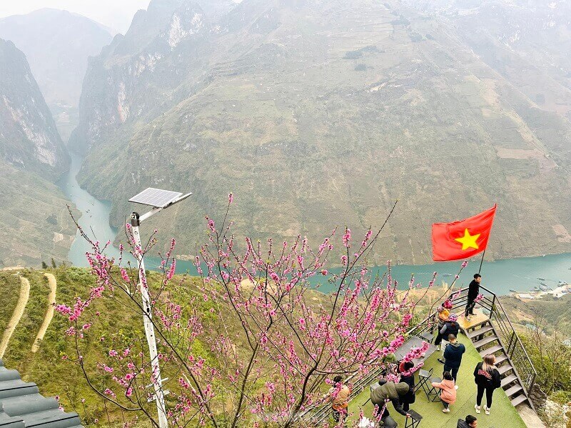 Từ địa điểm trên đỉnh đèo, du khách có thể ngắm trọn vẹn đỉnh núi tai mèo hùng vỹ cùng dòng sông Nho Quế thơ mộng ở phía dưới